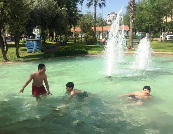 Çocuklar tehlikeye aldırmadan girdikleri süs havuzunda serinlediler